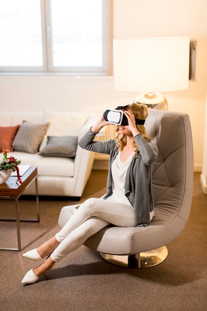 Woman wearing virtual reality goggles in the room