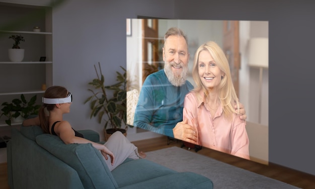 Woman wearing vr headset communicating online with senior parents indoor
