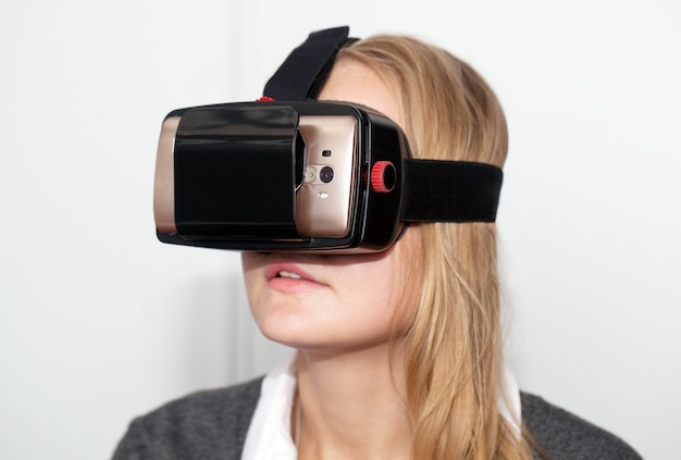 Woman wearing VR-headset over white background