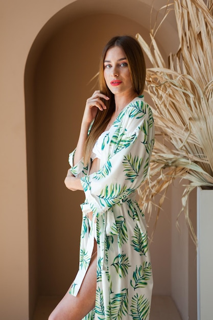 Woman wearing a white dress with palm leaves on it