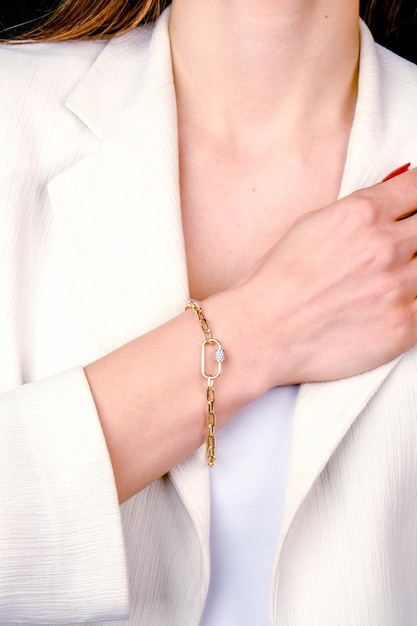 a woman wearing a white jacket with a gold chain on it