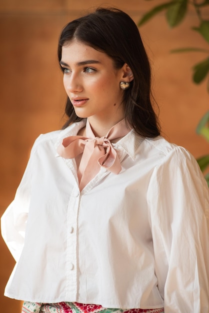 a woman wearing a white shirt with a bow on it