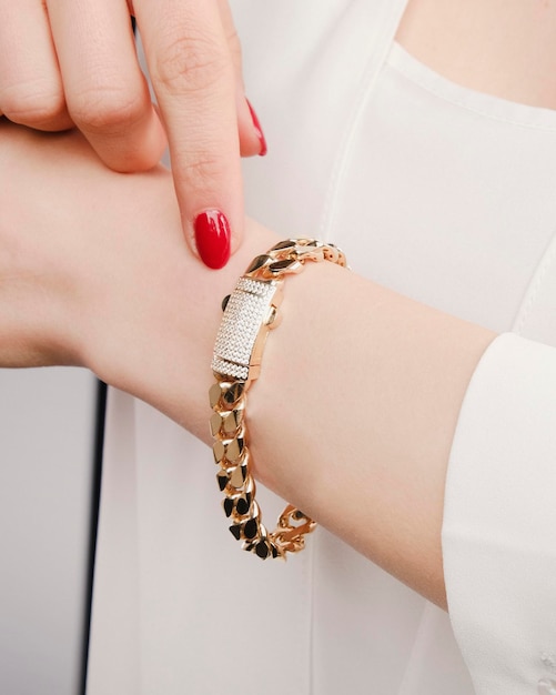 a woman wearing a white shirt with a gold bracelet on it