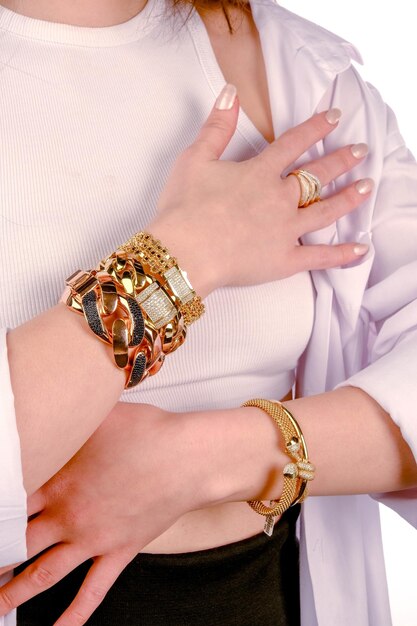 a woman wearing a white shirt with gold bracelets and a gold bracelet