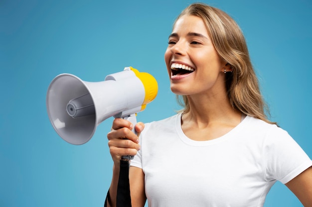 Photo woman wearing white t shirt holding megaphone shouting laud announcing sale isolated on background