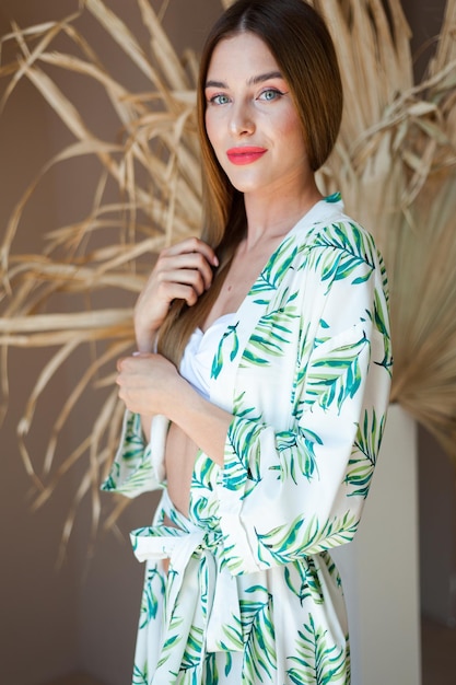 Woman wearing a white top with palm leaves on it