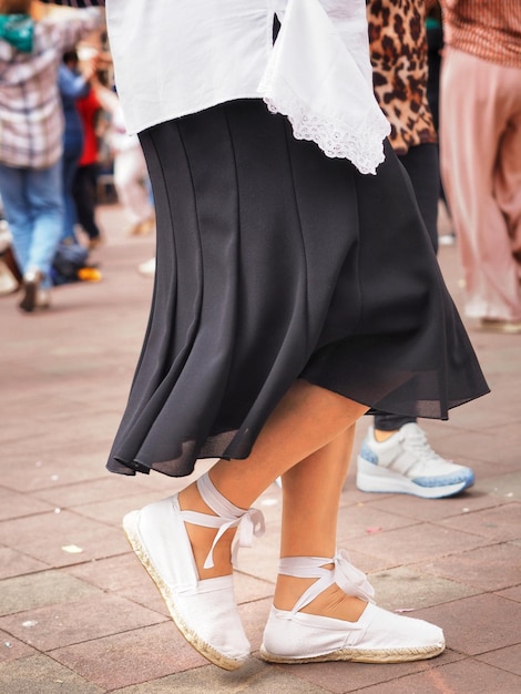 Woman wearing White traditional shoes dancing the sardana a Catalan folk dance Closeup view