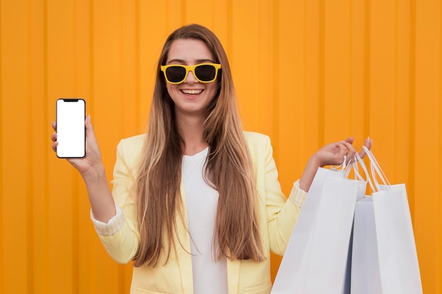 写真 黄色い服を着て、携帯電話を保持している女性