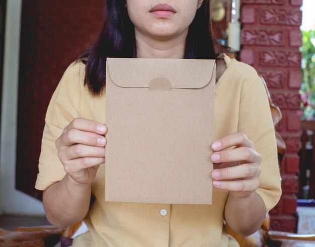 Foto una donna che indossa una camicia gialla e tiene una busta di carta