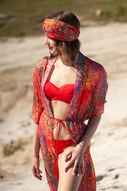 A woman wears a red kimono with a red hat and a red scarf.