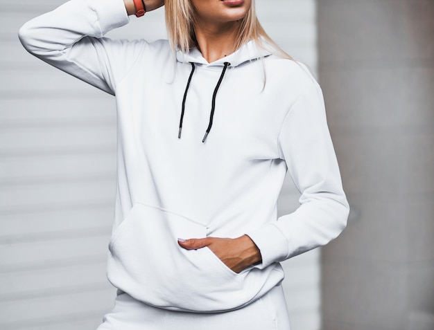 Woman wears a white basic hoodie No logo street wear brand design Design mockup for clothing logo