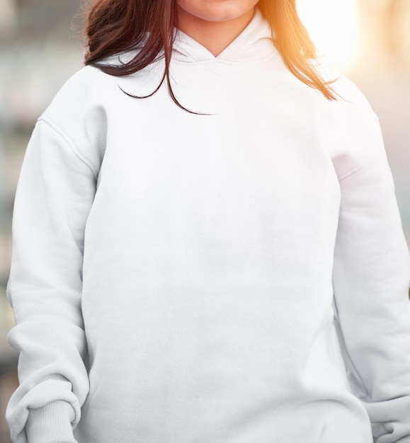 Foto la donna indossa una felpa con cappuccio bianca lo spazio vuoto sulla camicetta è per il design del logo e il mockup di abbigliamento per il branding modello di felpa di base