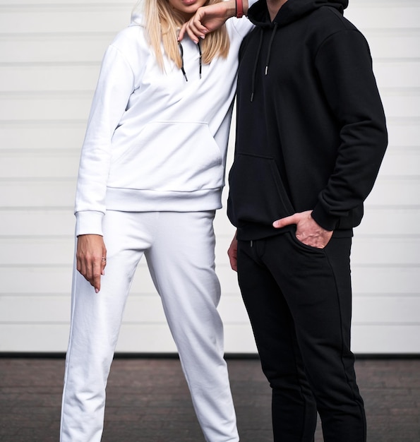 Woman wears white hoodie and man wears black hoodie Clothing mockup Streetwear design template