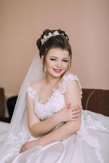 結婚式のドレスを着た女性がベッドに座っている