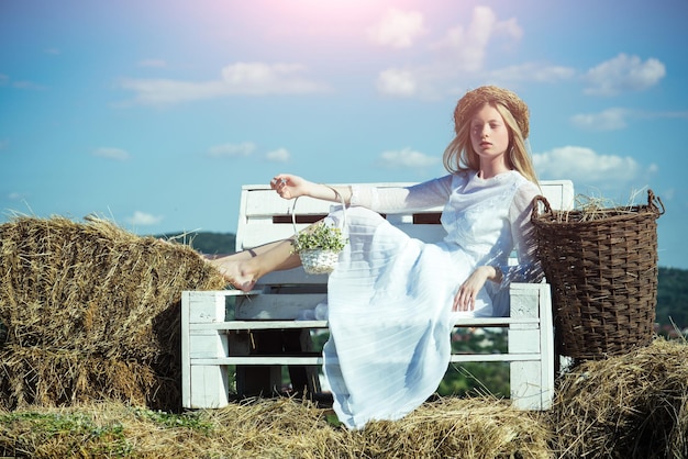 Woman in wedding dress on wooden bench woman in wreath on long blond hair