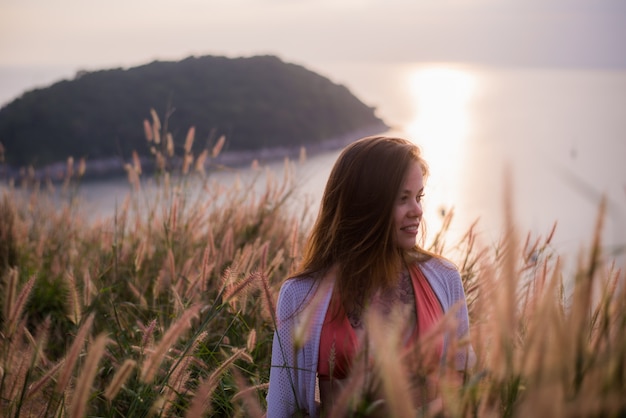 Donna in un campo di grano su un tramonto estivo