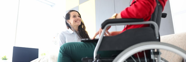 Woman in wheelchair communicates with friend at home closeup