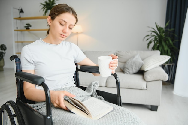 Woman in wheelchair reading book at home