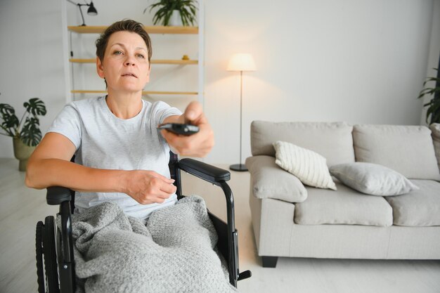 Woman in wheelchair uses a tv remote control