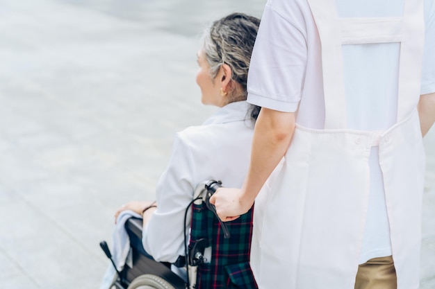 A woman in a wheelchair and a woman in an apron to care for