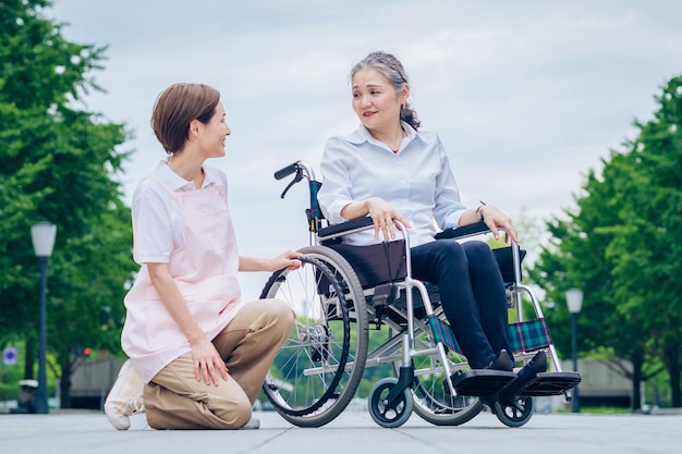 Una donna su una sedia a rotelle e una donna con un grembiule