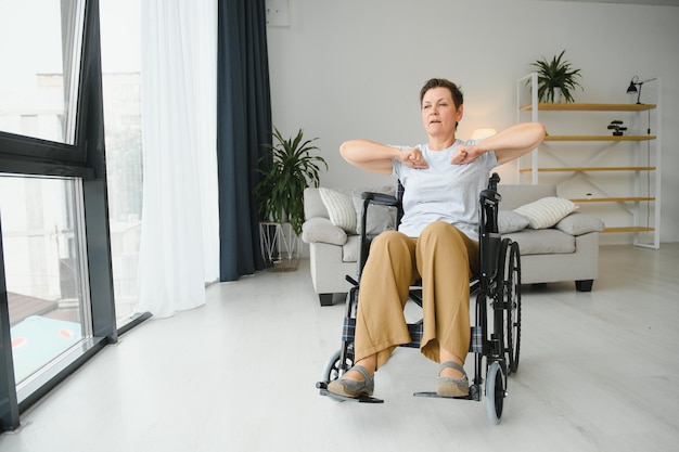 Женщина в инвалидной коляске тренируется в гостиной
