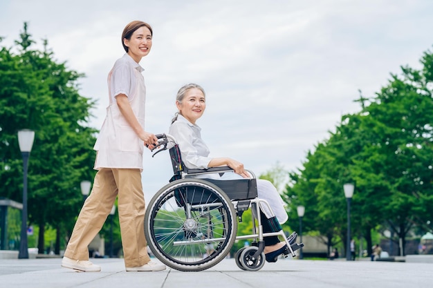 A woman in a wheelchair and young woman in an apron to care for