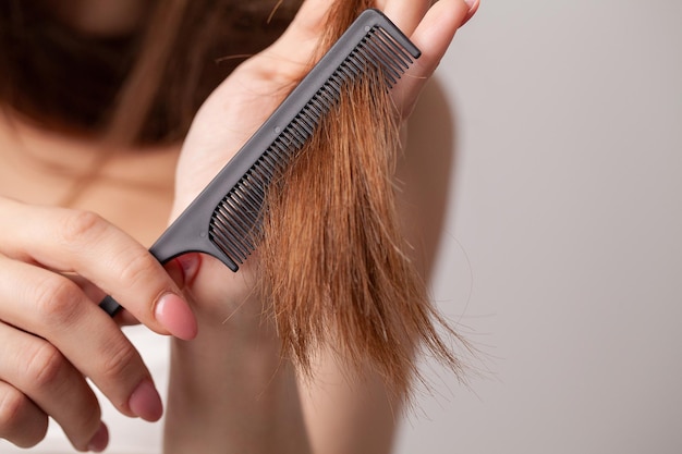 Woman on a white background with a comb for the hair the hair problem