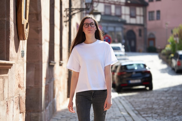 Woman in white blank tshirt wearing glasses in the city