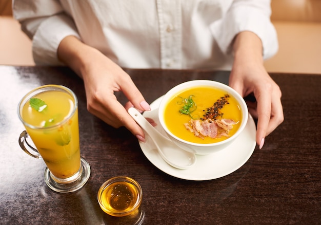 레스토랑에서 맛있는 식사를 주문하는 흰 블라우스에 여자.