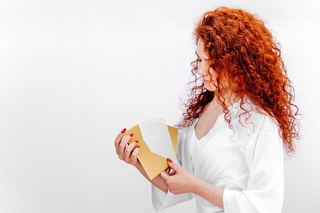 Foto una donna con un cappotto bianco con un buono regalo per trattamenti spa nelle sue mani