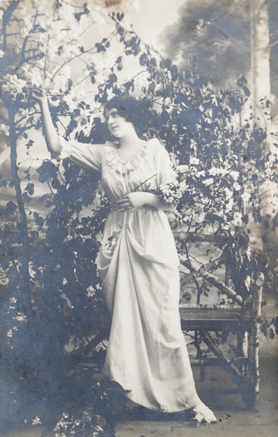 a woman in a white dress decorating chrsitmas tree