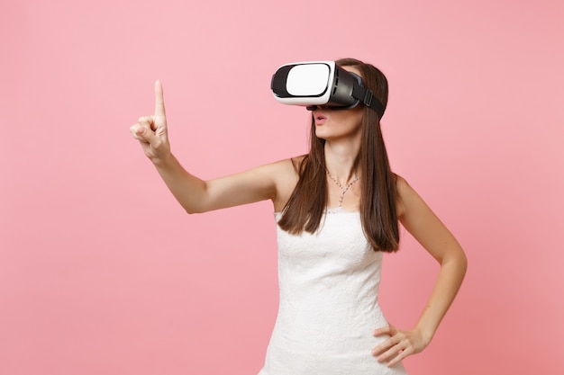 woman in white dress, headset of virtual reality touch something like push on button or pointing at floating virtual screen 