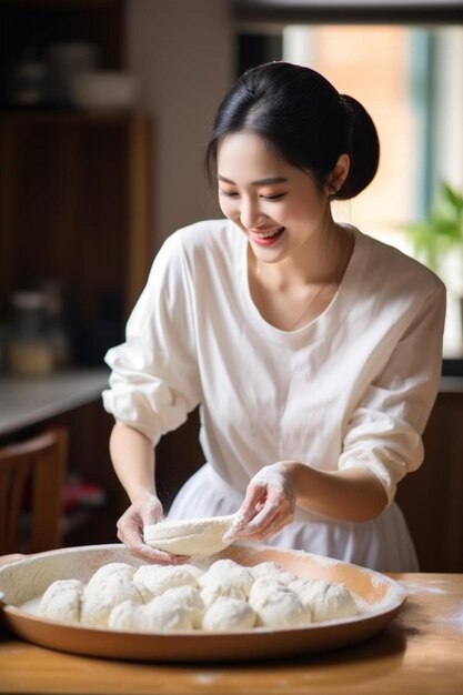 Photo a woman in a white dress is making dumplings with a knife