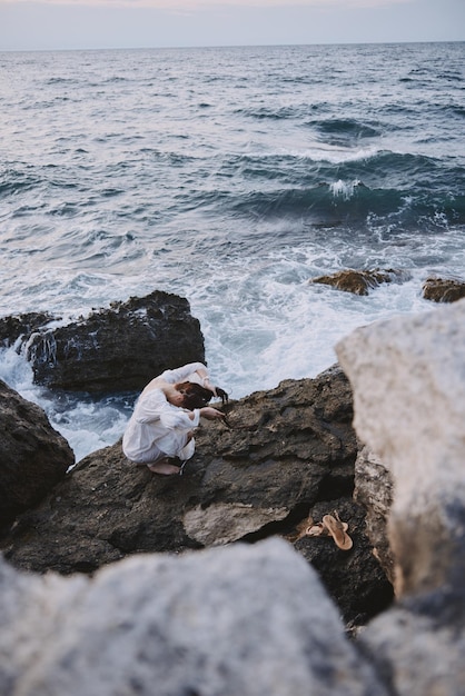 Woman in white dress rocks nature landscape ocean travel unaltered