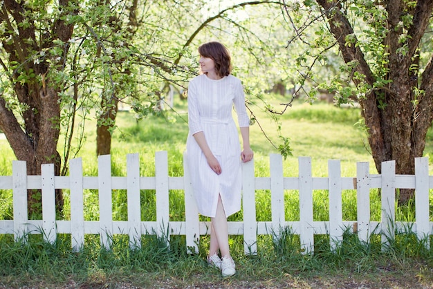 Женщина в весеннем саду в белом платье