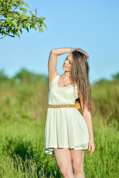 a woman in a white dress stands under a tree