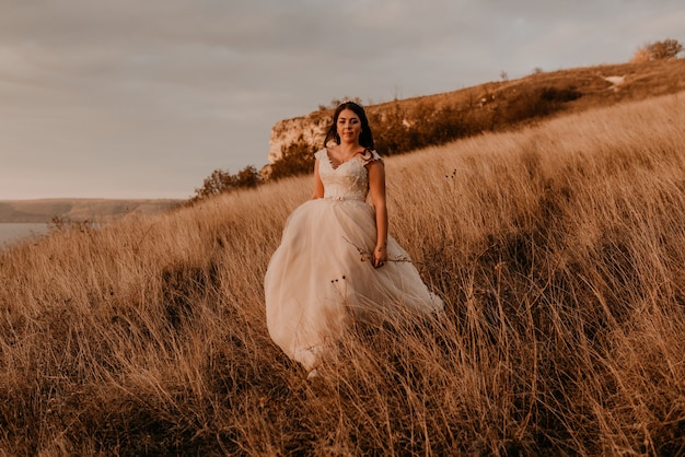 woman in white dress walking on tall grass in field