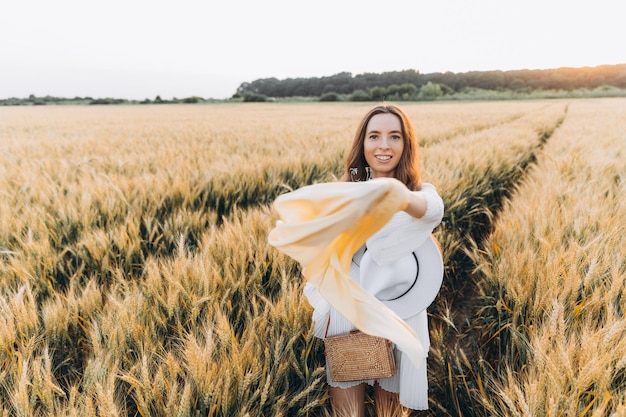 woman in a white dress and a white hat in a wheat field