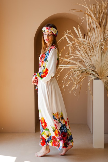 A woman in a white dress with a floral pattern on the front