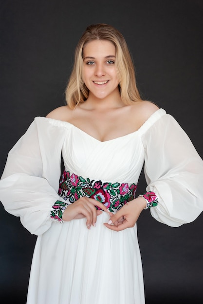 A woman in a white dress with a floral pattern on the sleeves