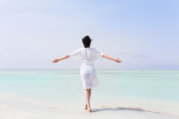 Woman in white dress with raised hands