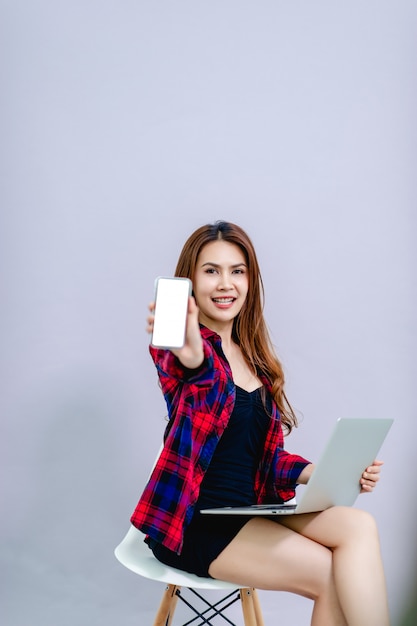 The woman and the white screen phone place the space and have a computer ready to work all the time.