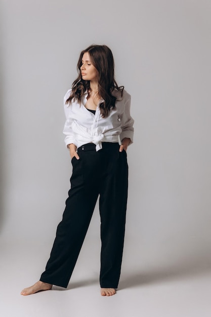 A woman in a white shirt and black pants