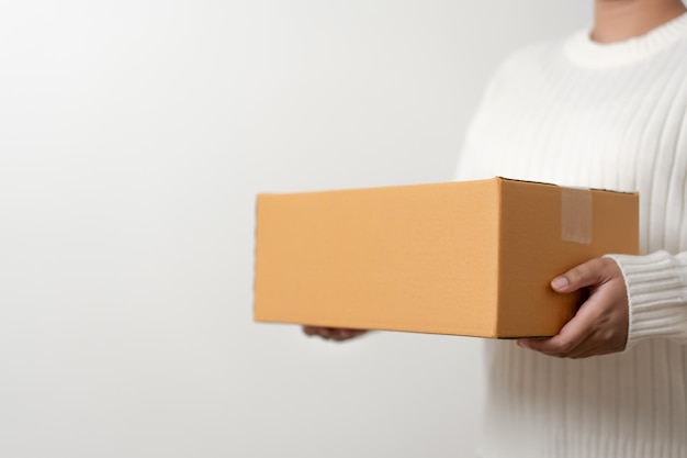 Woman in white shirt carrying paper cardboard boxes mail and\
postal delivery