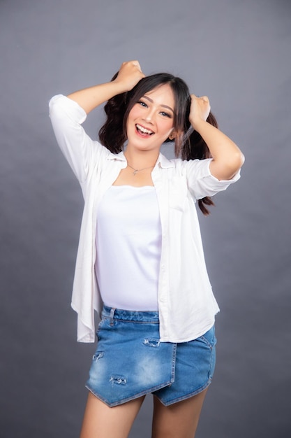 A woman in a white shirt and denim skirt is posing for a photo promo hairstyle fashion store banner