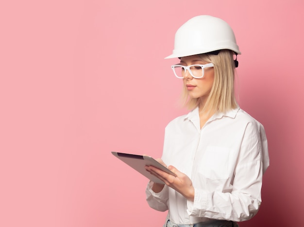 Foto donna in camicia bianca, occhiali e casco con tavoletta