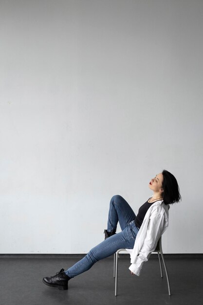 Photo a woman in a white shirt sits on a chair