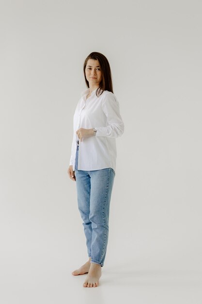 Photo a woman in a white shirt stands in front of a white background