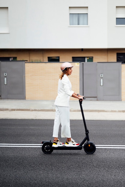 woman in white suit on an electric scooter